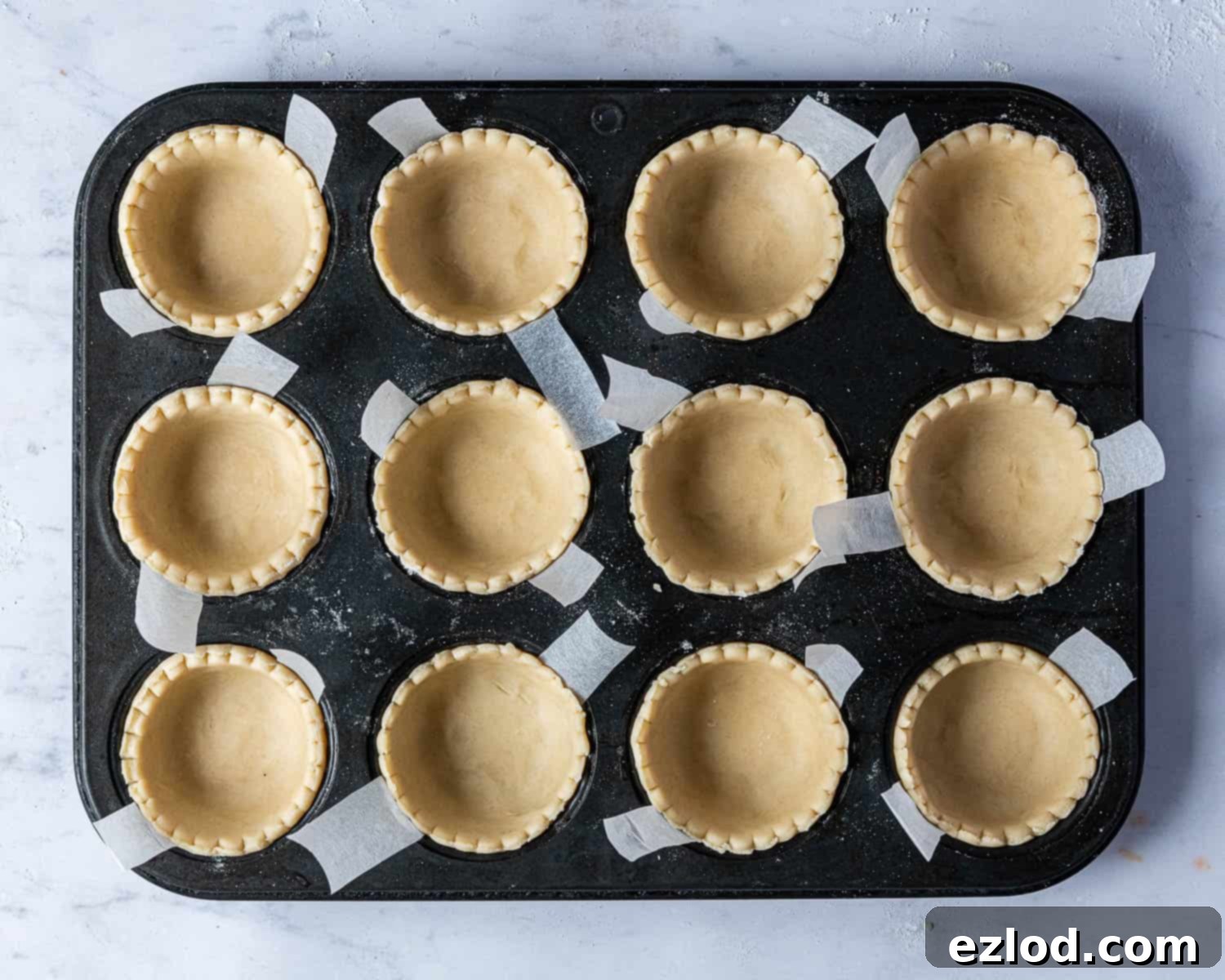 A muffin tin lined with pastry cases.