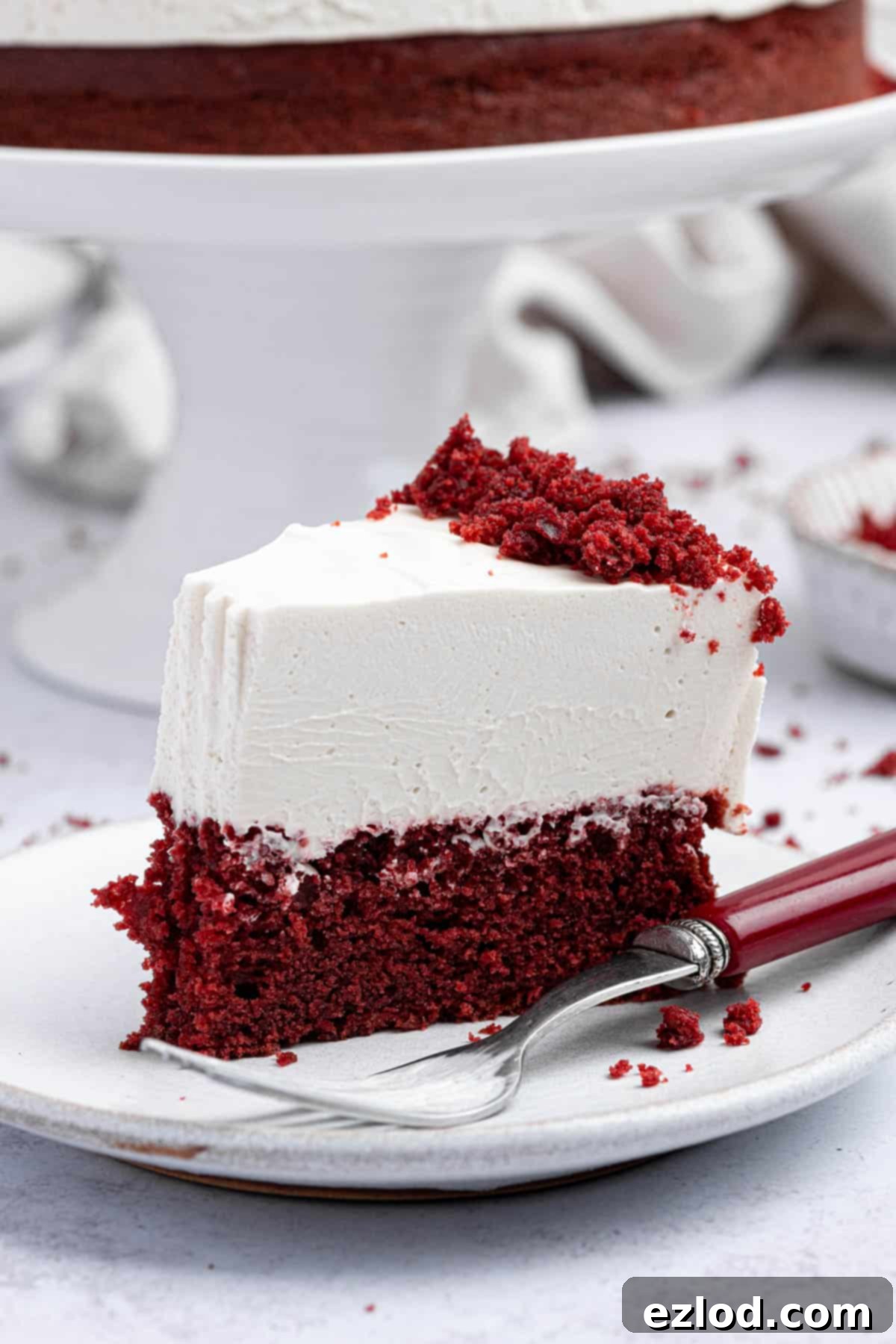 A slice of vegan red velvet cheesecake cake with a forkful removed.