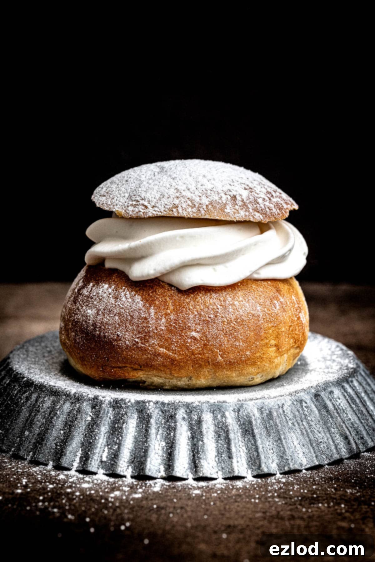 Homemade Vegan Semlor 16 Close up of a vegan semla bun on a metal plate.
