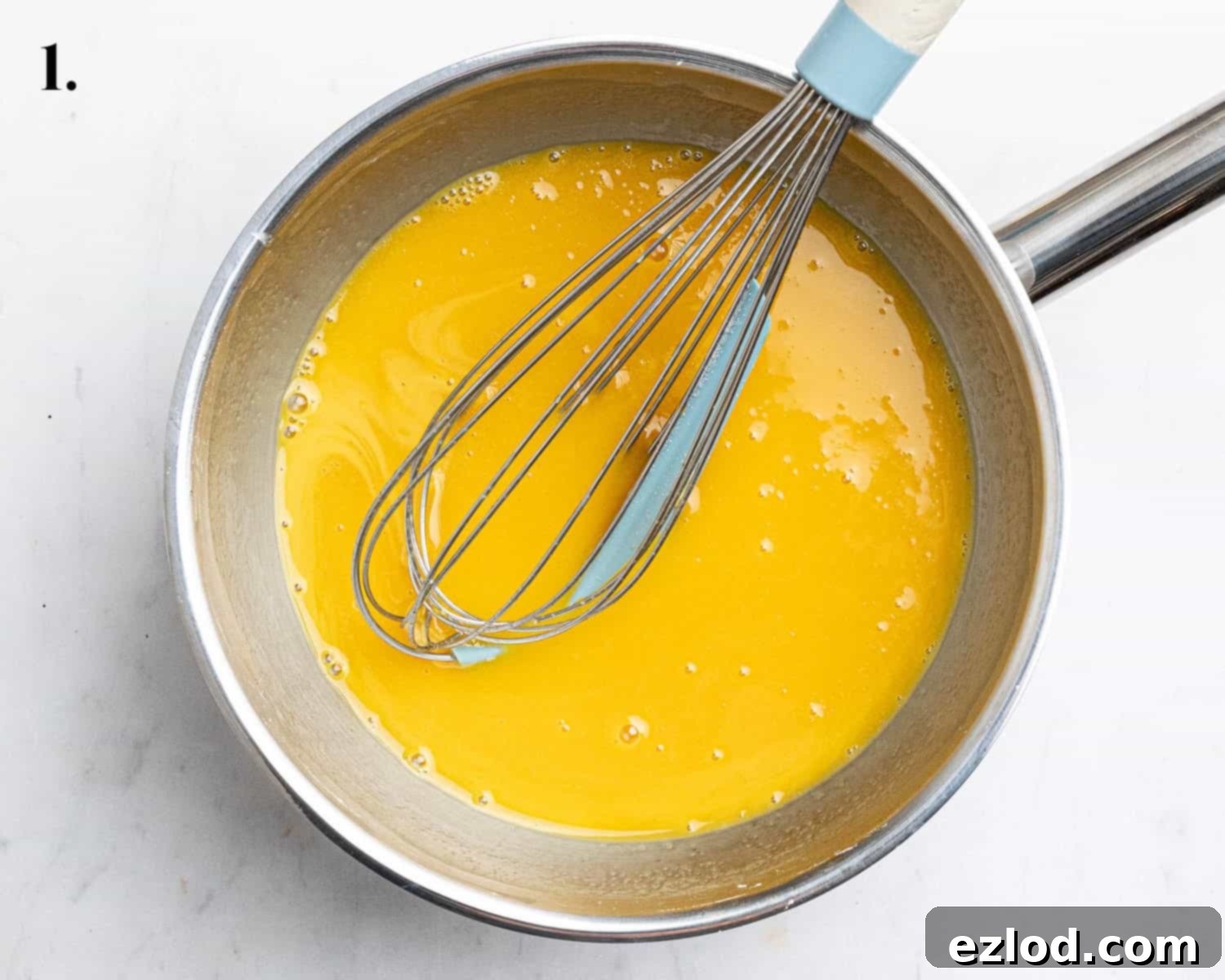 Step 1, the vibrant passion fruit puree being whisked with cornflour in a saucepan.