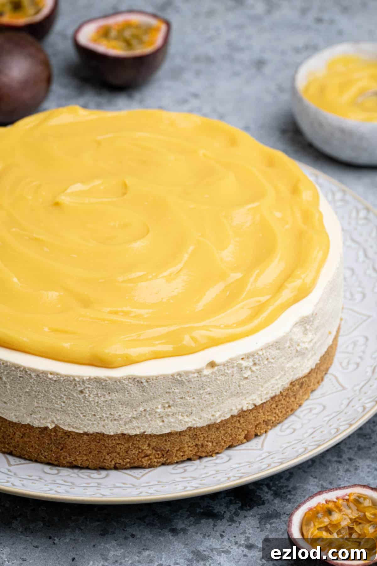 A close-up view of the vibrant, creamy vegan passion fruit cheesecake, showing its smooth texture and topping.