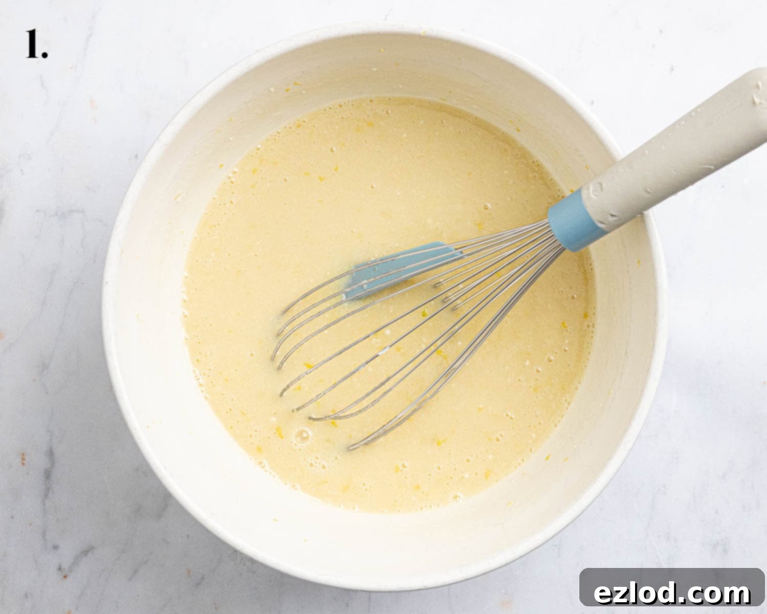 Step 1: All the wet ingredients, including lemon zest, milk, yogurt, oil, sugar, and vanilla extract, thoroughly mixed together in a large bowl, forming a smooth liquid base.