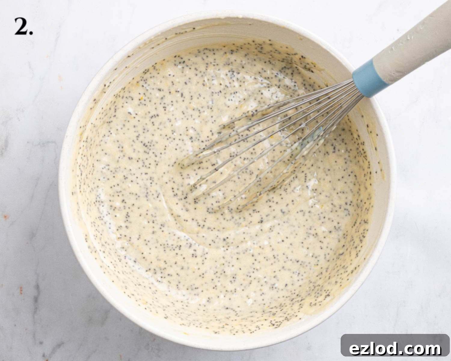 Step 2: The completed muffin batter, gently mixed with all dry ingredients and poppy seeds, resting in a large bowl.