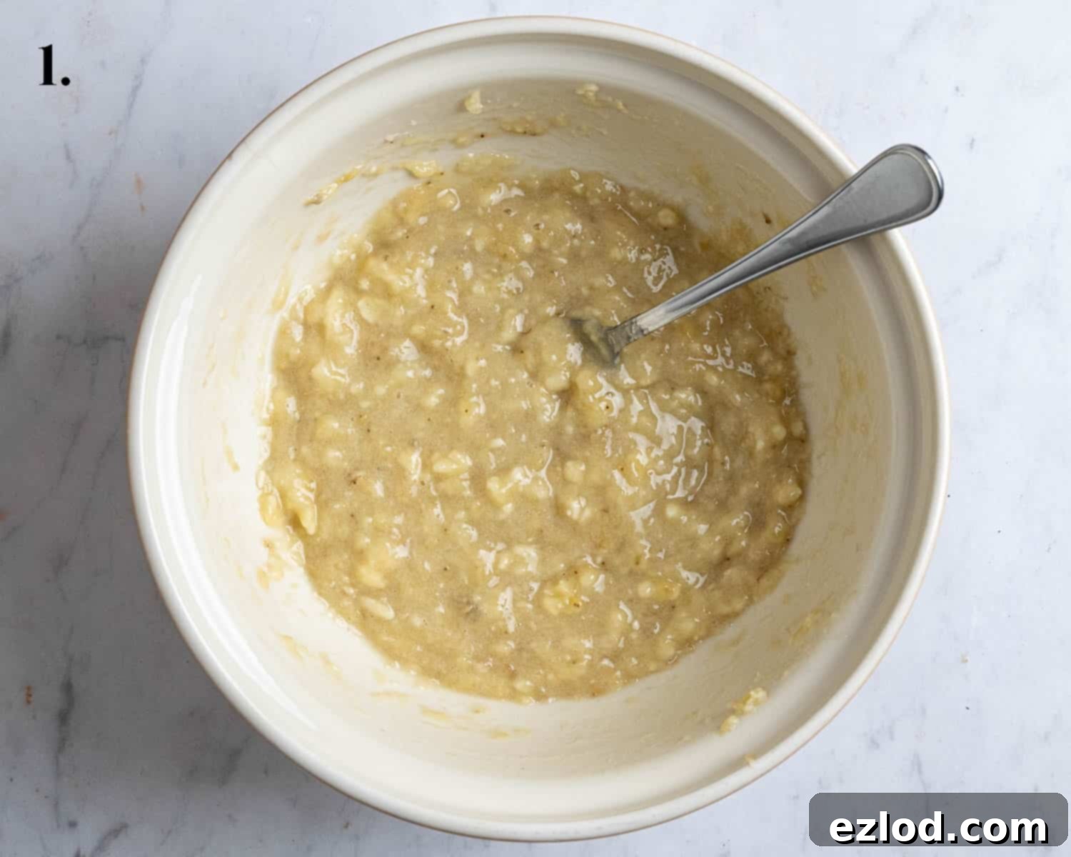 Step 1: A bowl filled with thoroughly mashed, very ripe bananas, ready for the wet ingredients.