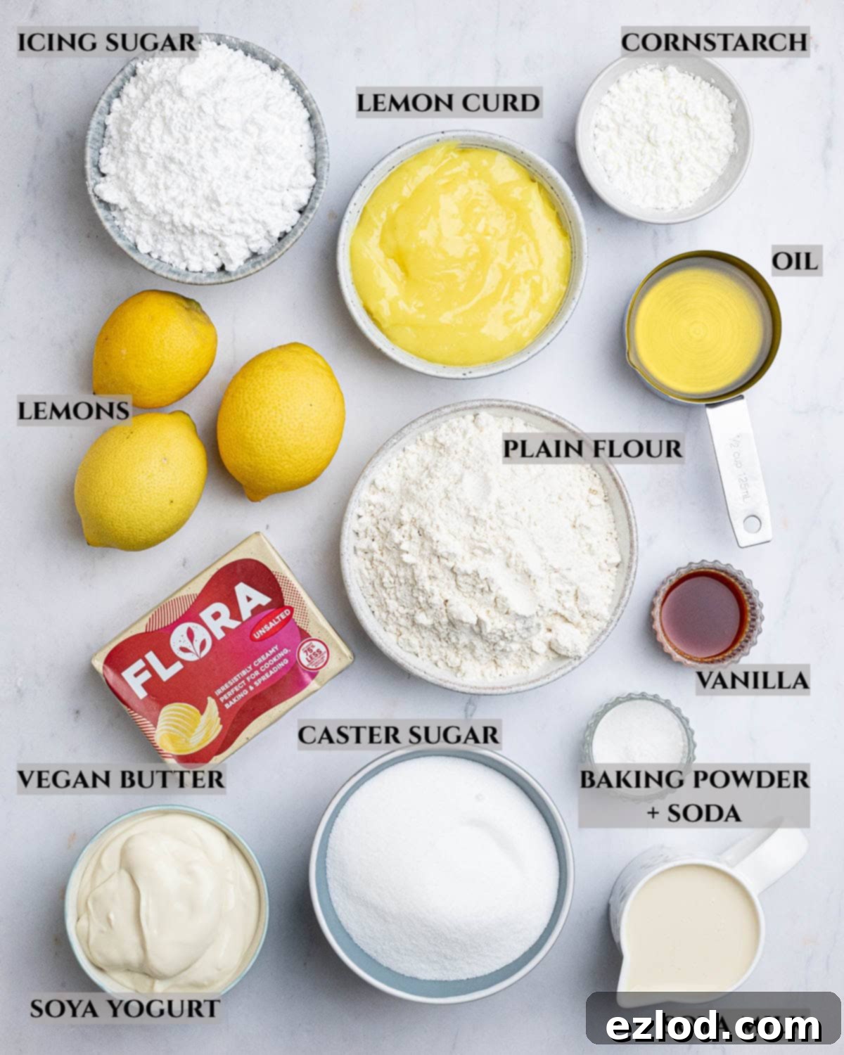 A visually appealing labeled photo displaying all the essential ingredients required to bake a delicious vegan lemon layer cake, neatly arranged.