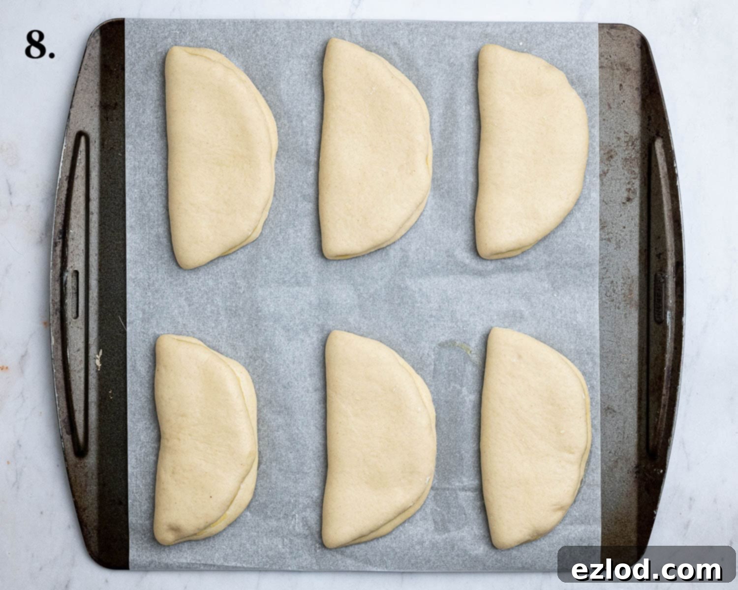 Step 8, the coco breads on a baking sheet after rising.