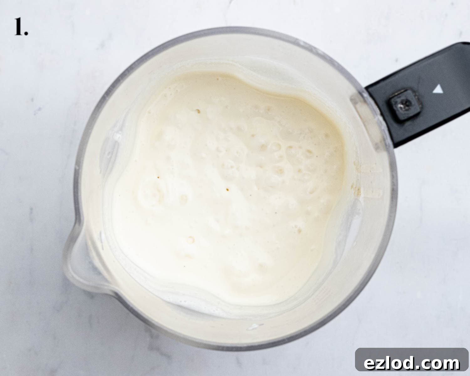 Step 1 in making vegan strawberry cheesecake ice cream: a blender full of the smooth, blended ice cream base mixture.