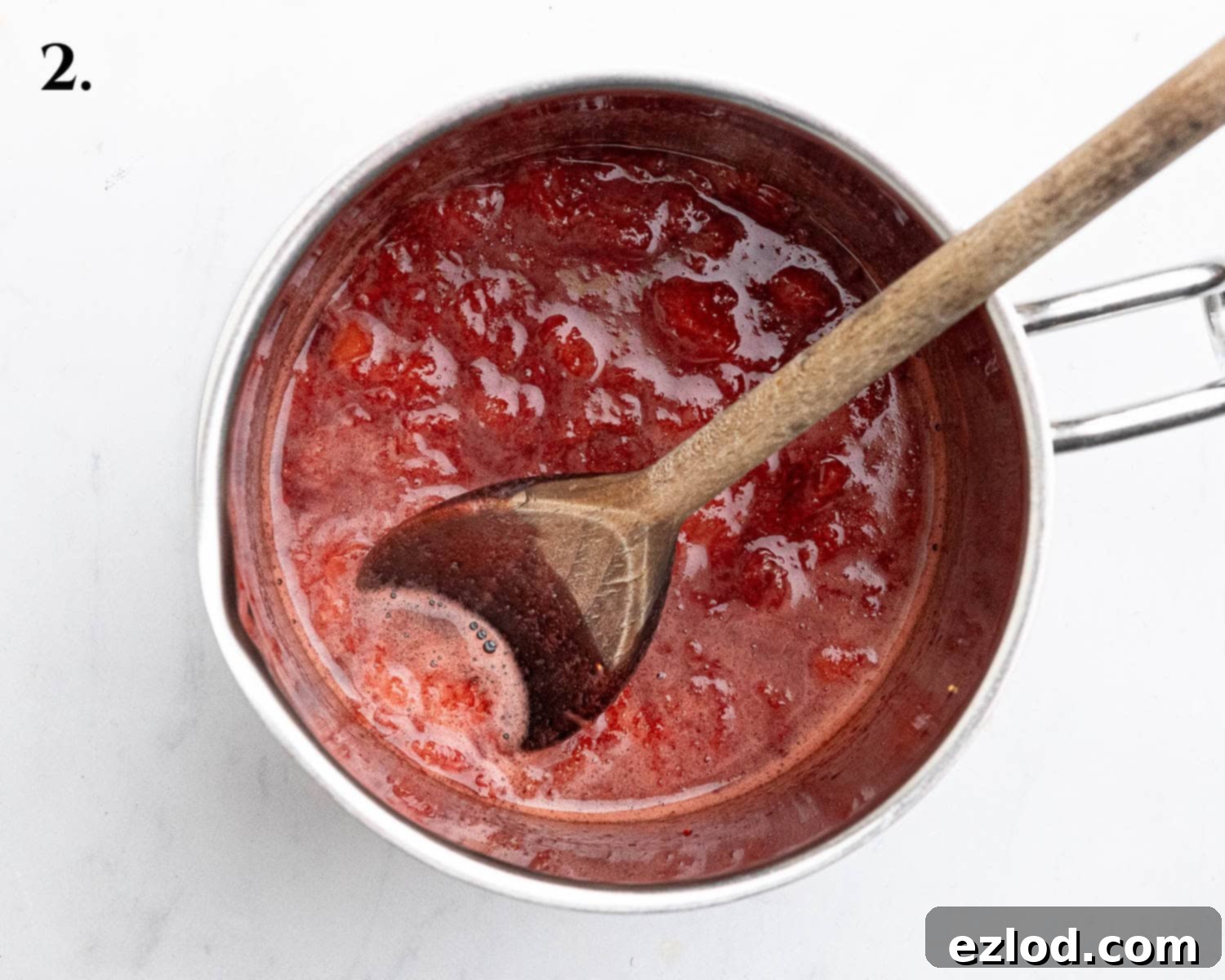 Step 2 in making vegan strawberry cheesecake ice cream: a pan of cooked, softened strawberries, ready for thickening.