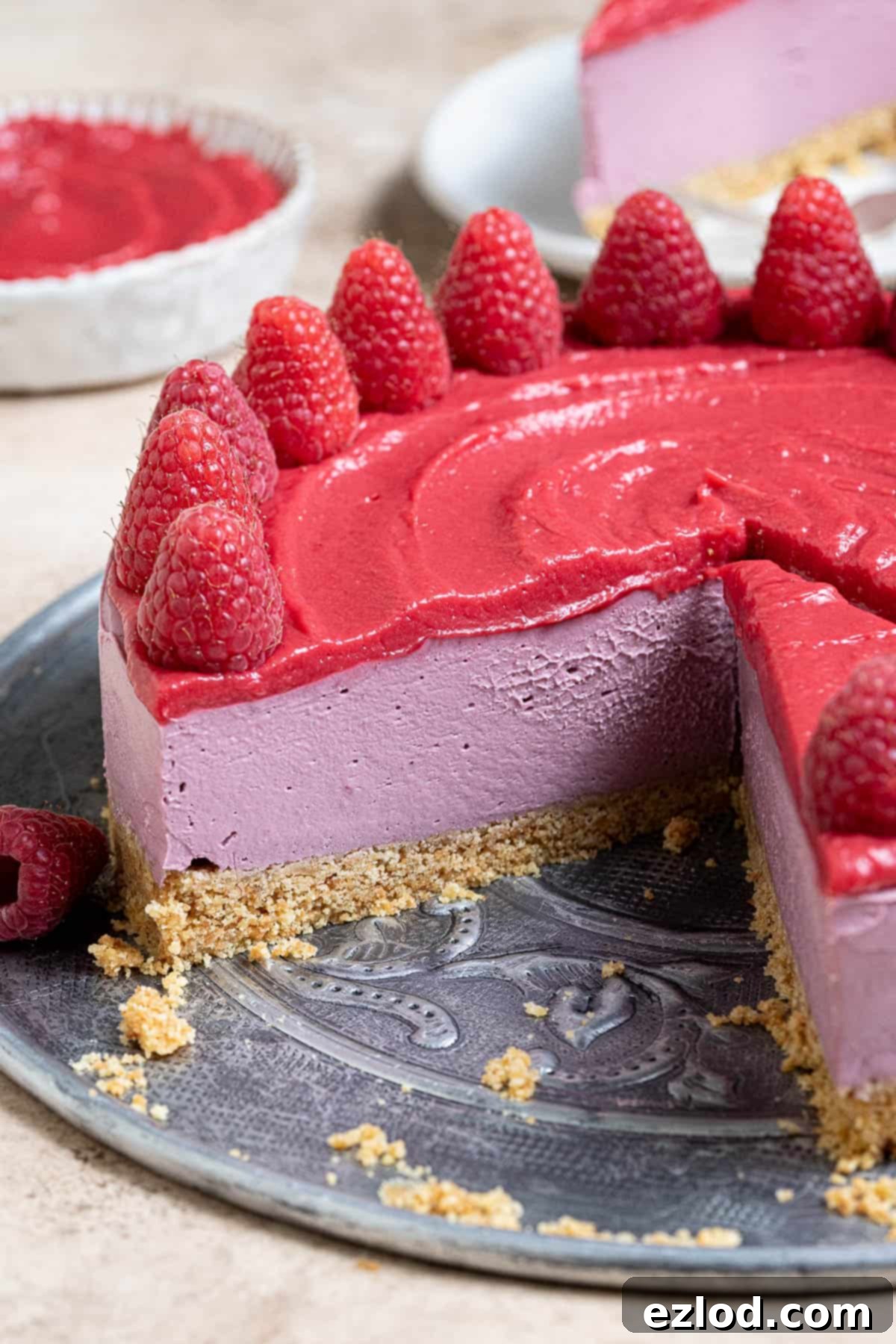 A close-up view of the perfectly sliced vegan raspberry cheesecake, showing the vibrant layers and smooth texture, ready to be enjoyed.