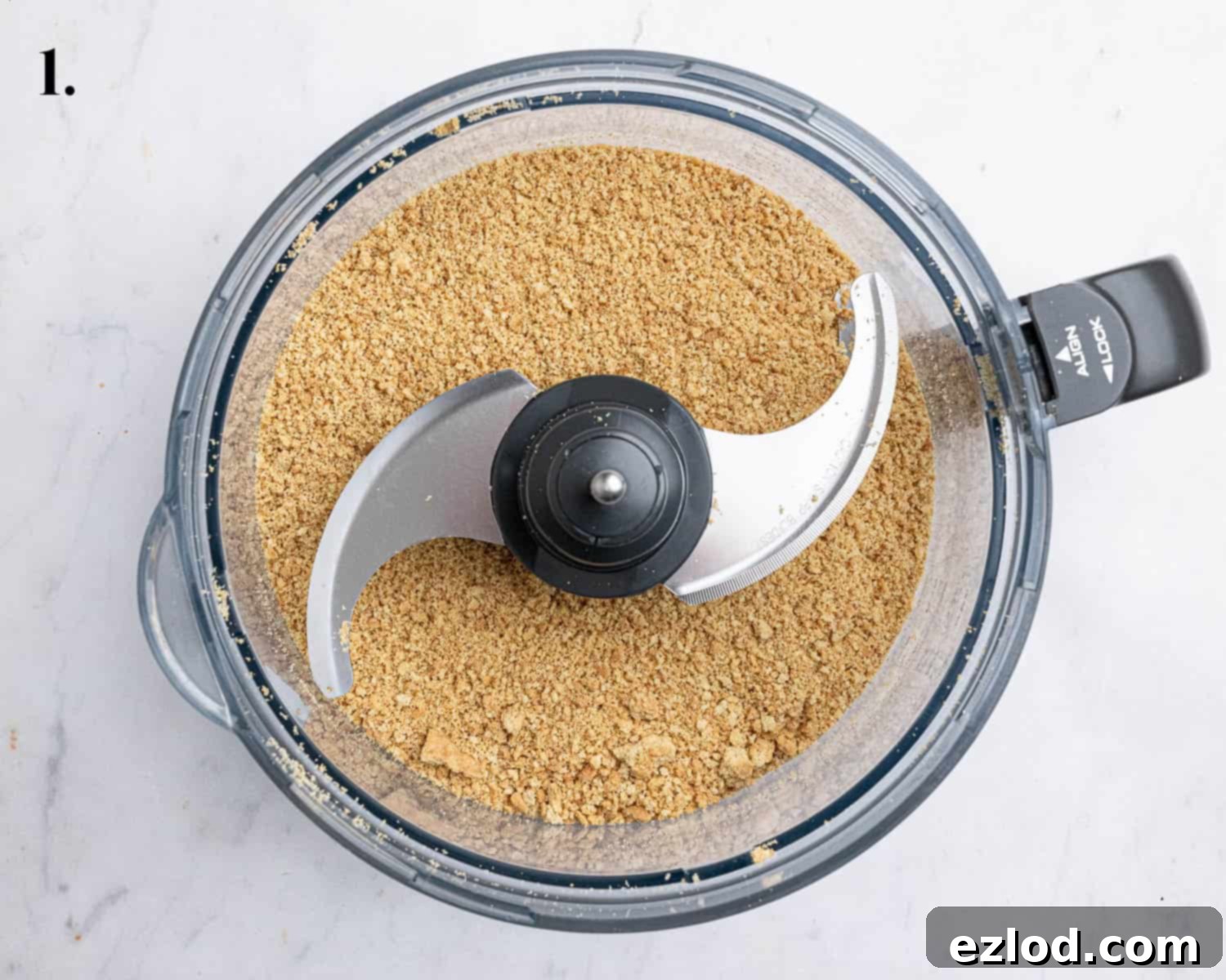 Step 1, the blended cookies in a food processor, ready to form the base of the cheesecake.