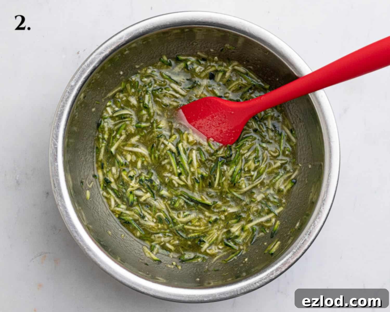 Vegan Zucchini Spice Cake 6 Step 2: The wet ingredients (light brown sugar, neutral oil, vinegar, and vanilla extract) thoroughly combined with grated courgette in a bowl, creating a homogenous mixture.