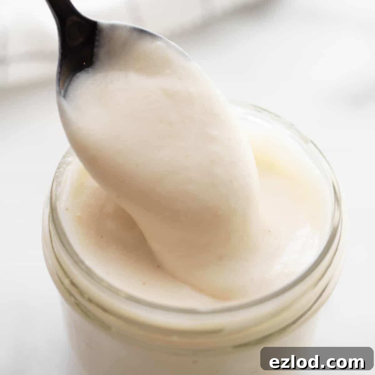 Spoon dipping into a mason jar of healthier cream of chicken soup.