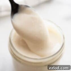 Spoon dipping into a mason jar of healthier cream of chicken soup.