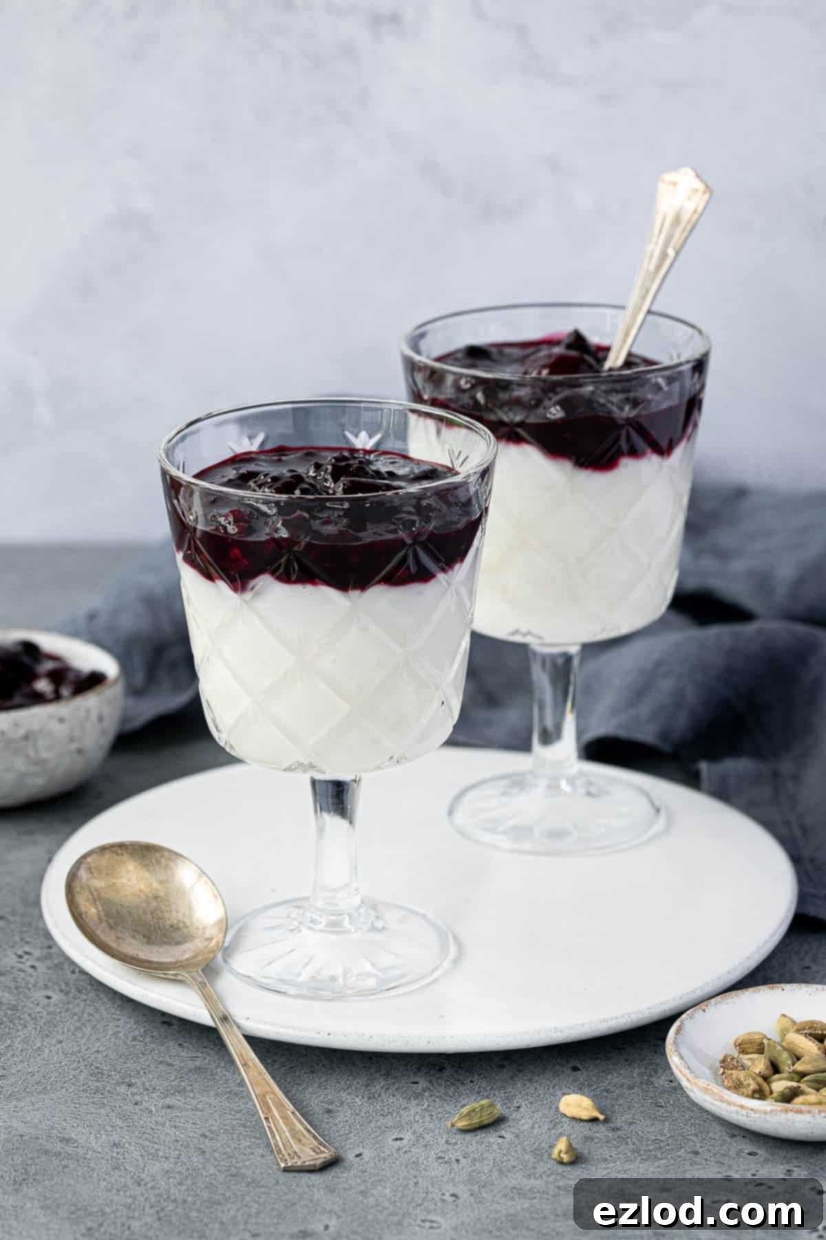 Two glasses of vegan coconut rice pudding topped with berry compote.
