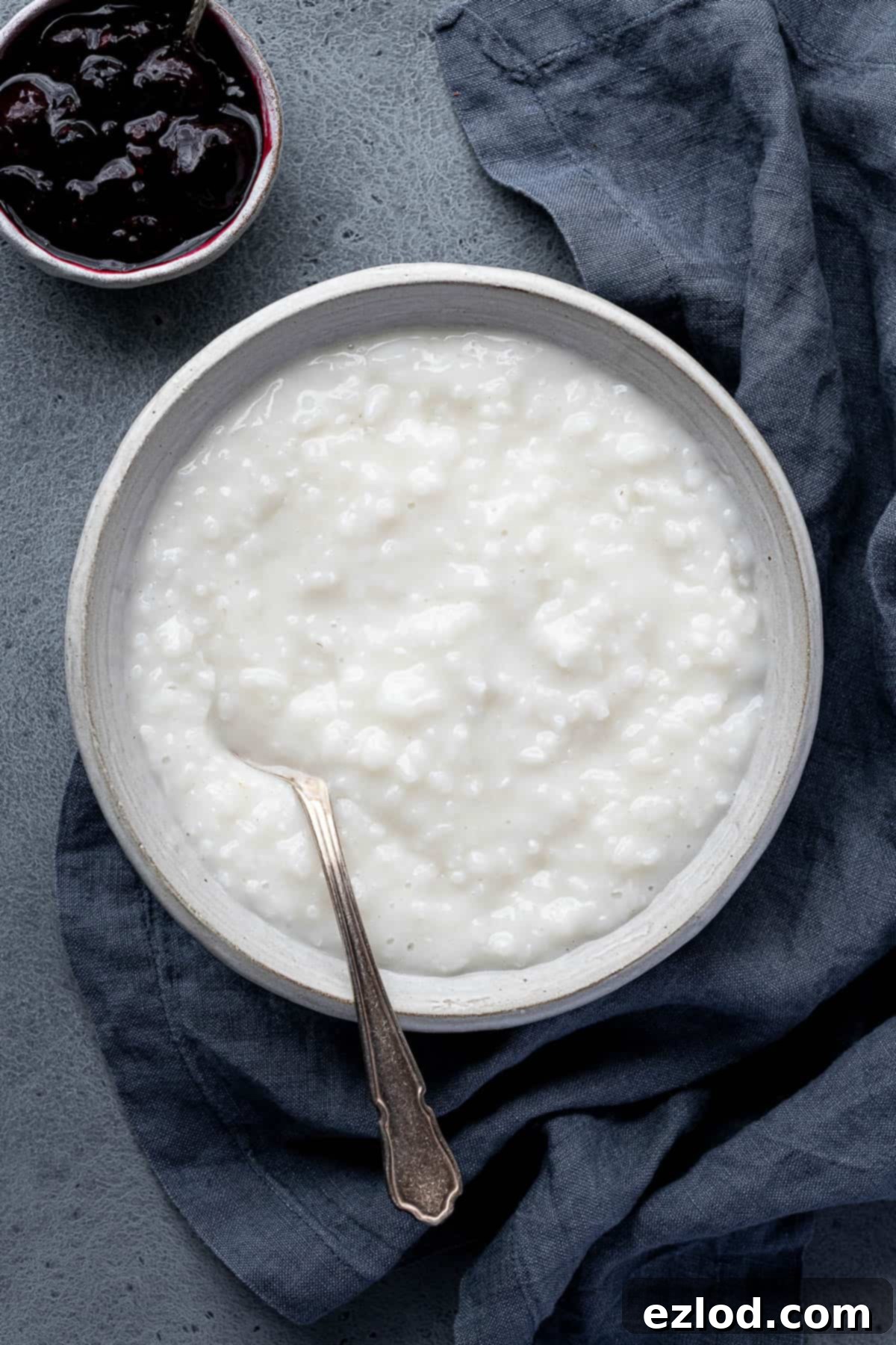A bowl of coconut rice pudding with a bowl of berry compote.