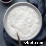 A bowl of coconut rice pudding with a bowl of berry compote.