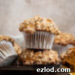 A stack of two vegan pumpkin streusel muffins in a muffin tin.