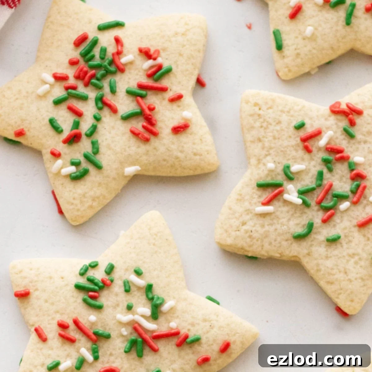 Close up of gluten free sugar cookies shaped like a star with red, green, and white sprinkles, showing their perfectly baked texture.