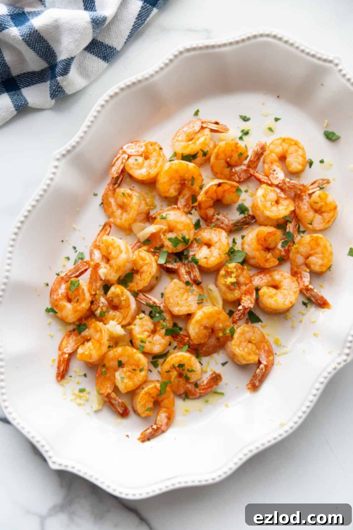 Overhead shot of Air Fryer Shrimp on a pretty white platter with scalloped edges.