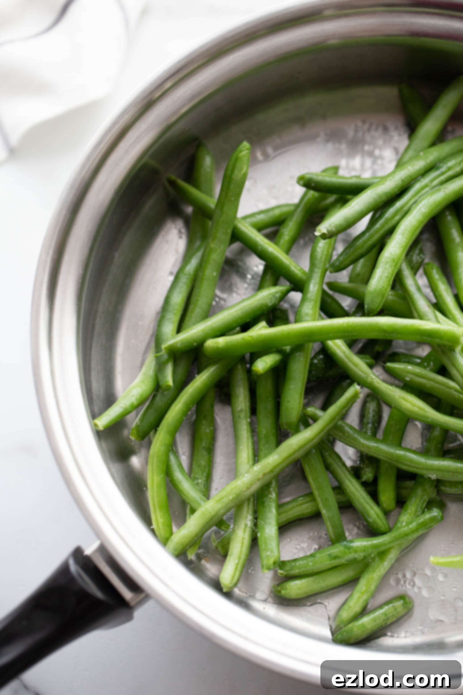 Skillet with green beans and water.