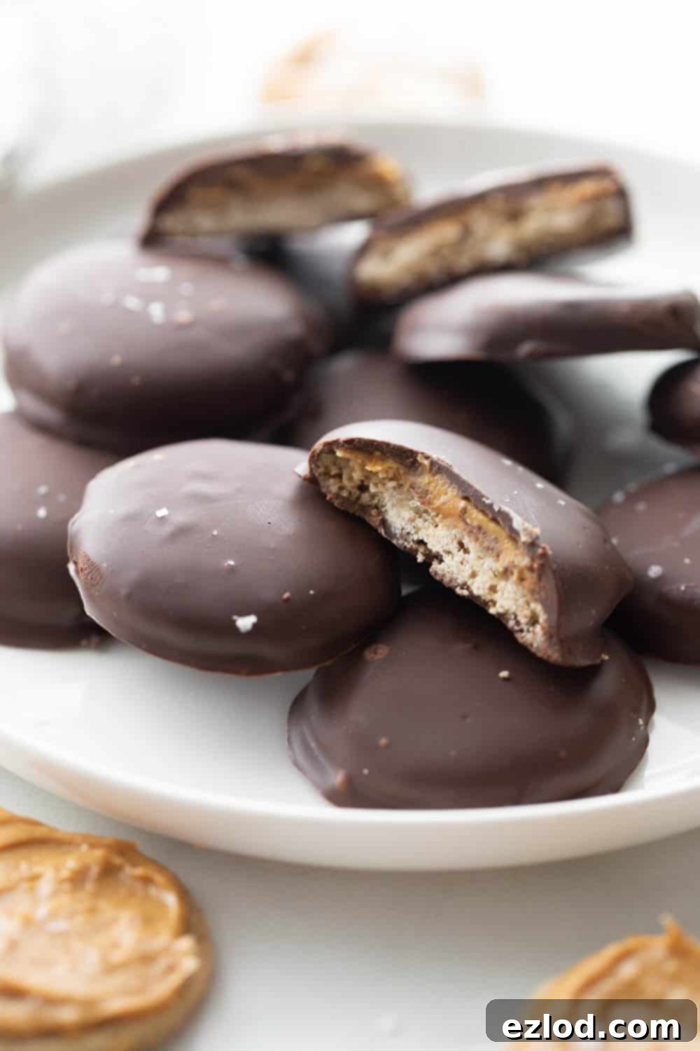 Plate of delicious gluten-free homemade Tagalongs with a sprinkle of flakey sea salt, showcasing the rich chocolate coating and inviting texture.