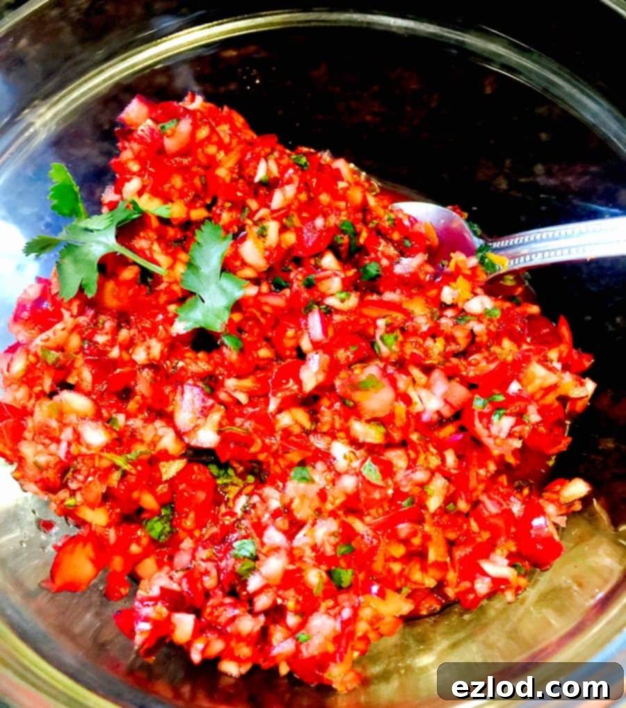 Finished Cranberry Salsa in a glass bowl with a serving spoon