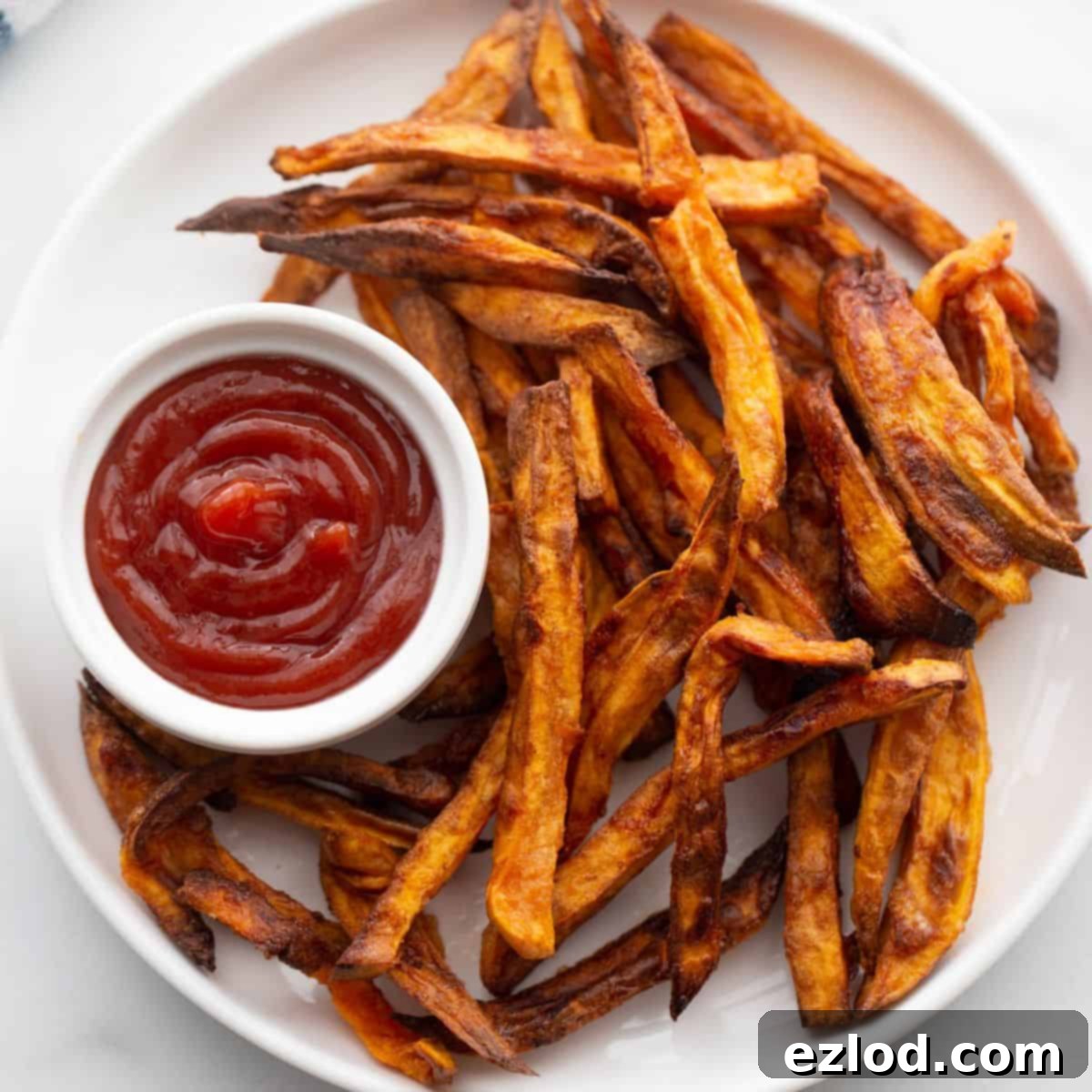 Perfectly Crispy Air Fryer Sweet Potato Fries 2 Plate of crispy golden brown air fryer french fries served with ketchup.