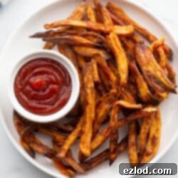 Perfectly Crispy Air Fryer Sweet Potato Fries 5 Plate of crispy golden brown air fryer french fries served with ketchup.