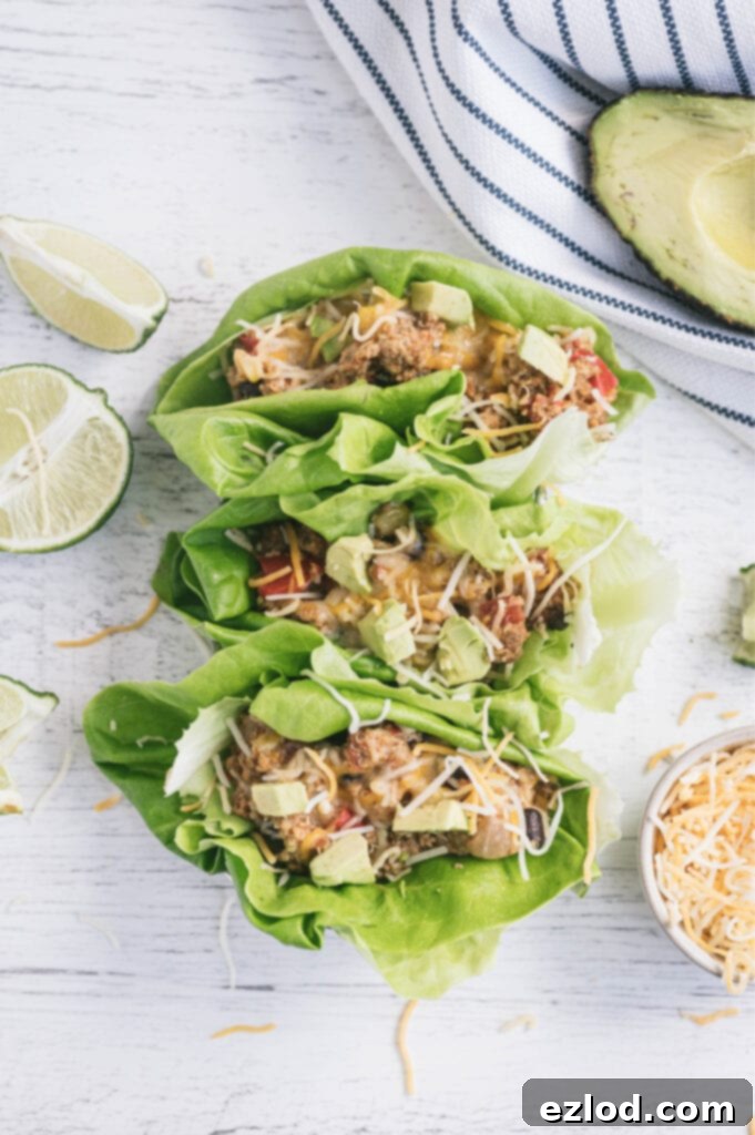 Overhead photo of lettuce wrapped taco casserole topped with diced avocado and shredded cheese