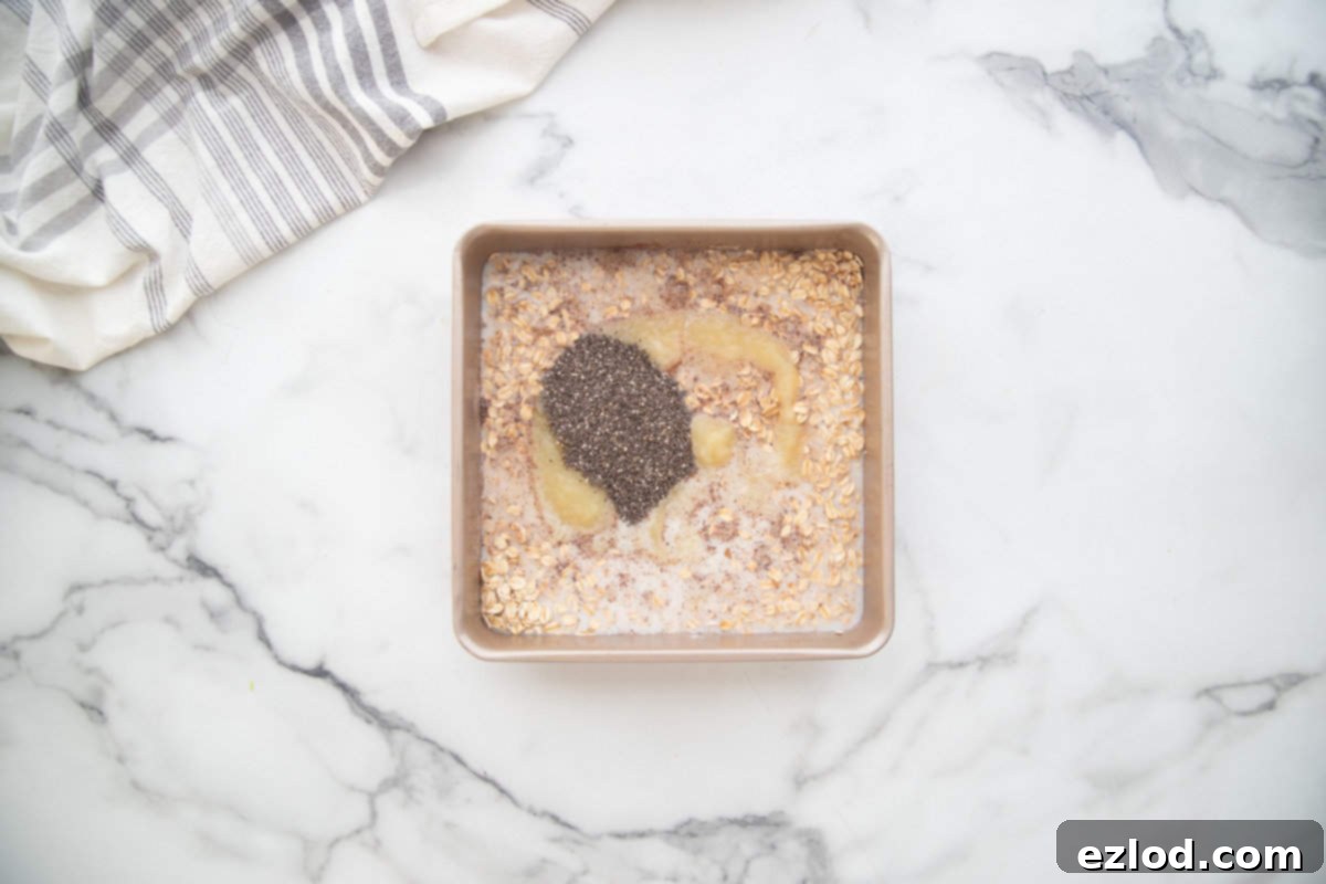 Ingredients for one pan baked oats mixed directly into a square baking dish.