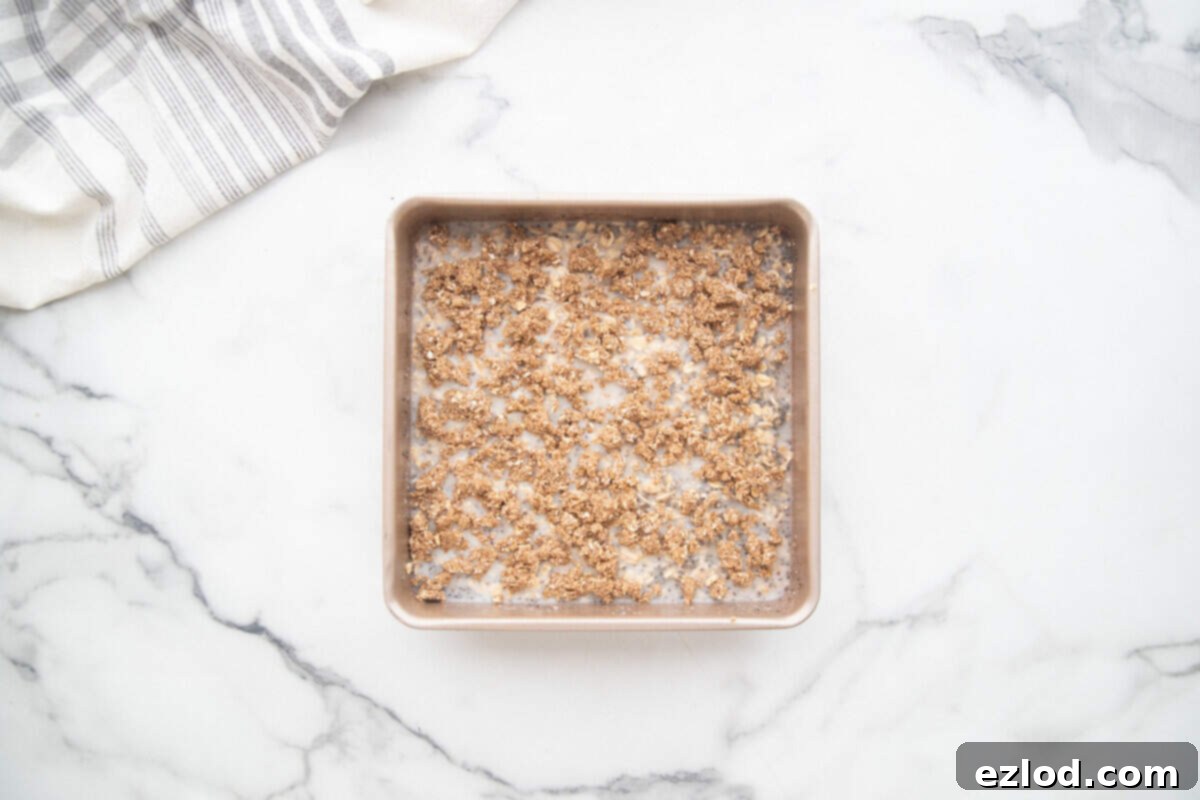 Coffee cake baked oatmeal with crumb topping in an 8x8 baking pan.