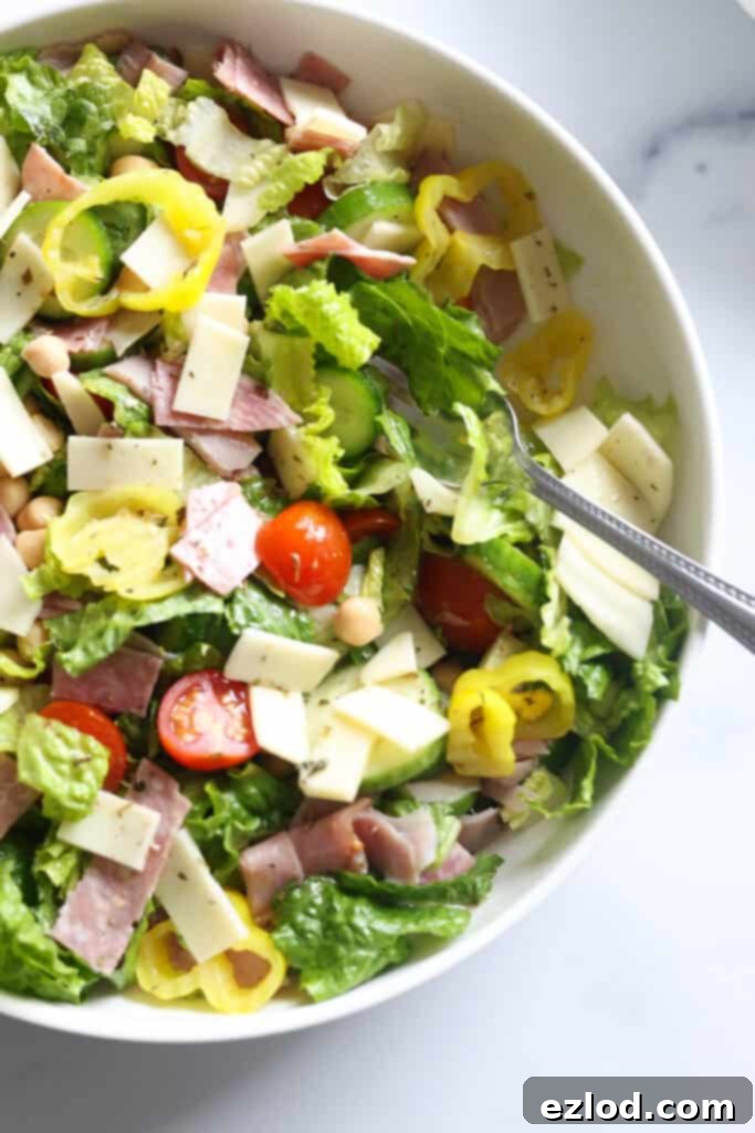 TikTok's Favorite Italian Grinder Chopped Salad 7 A close-up shot of a single bowl of freshly tossed Italian Chopped Grinder Salad, richly coated with homemade dressing and ready to be enjoyed.
