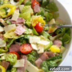 TikTok's Favorite Italian Grinder Chopped Salad 9 A mouthwatering bowl of Italian Chopped Grinder Salad on a white marble countertop, showcasing its vibrant colors and delicious ingredients.