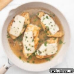 Weeknight Chicken Scallopini 8 Chicken scallopini in a white ceramic pan topped with thin mozzarella, capers, and fresh parsley.