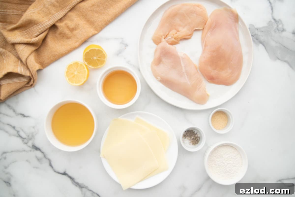 Weeknight Chicken Scallopini 5 Ingredients for chicken scallopini on a white marble table.