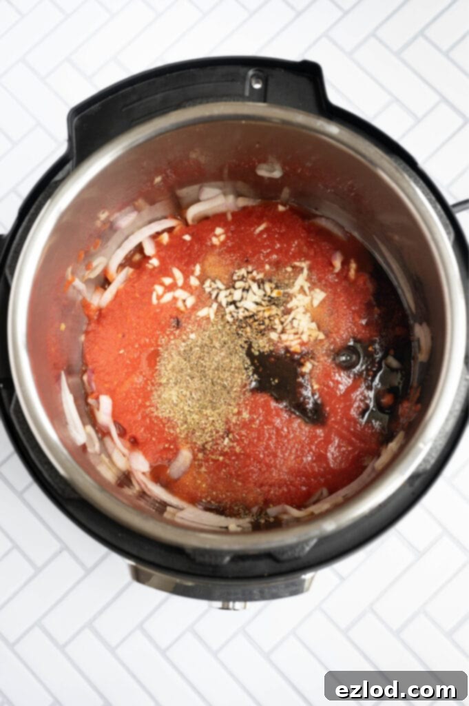 Overhead photo of an Instant Pot full of ingredients ready for balsamic chicken 