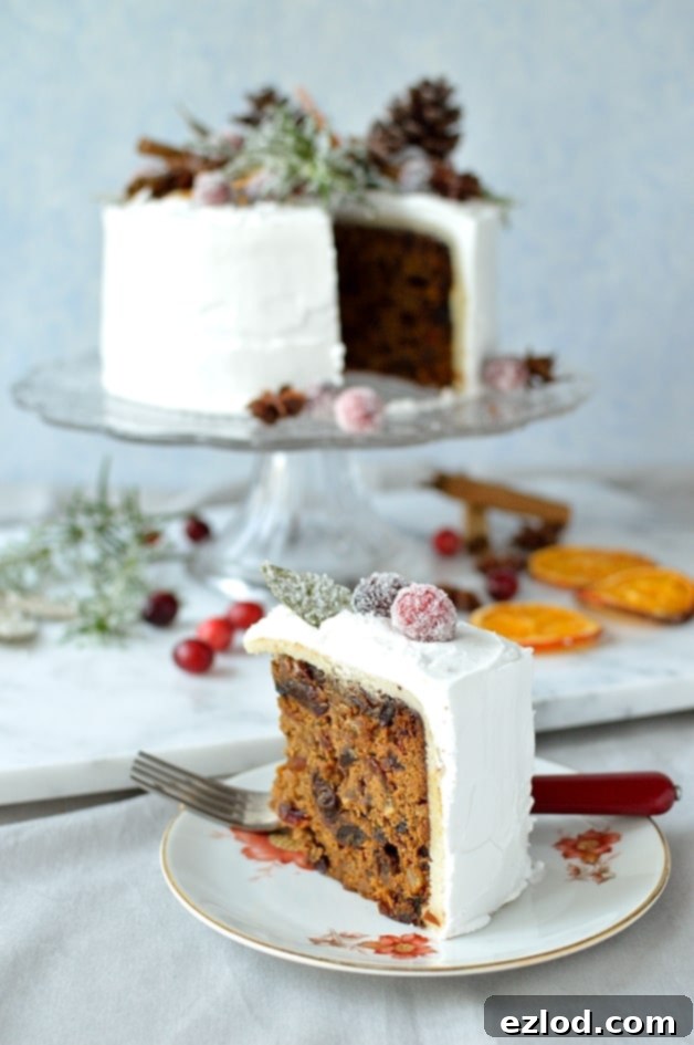 Moist ginger fruitcake topped with marzipan, royal icing, sugared cranberries, rosemary and bay leaves, dried orange slices, pine cones and whole spices - Domestic Gothess