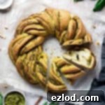 A close-up of a slice of vegan pesto bread, highlighting its soft interior and vibrant green pesto swirls.