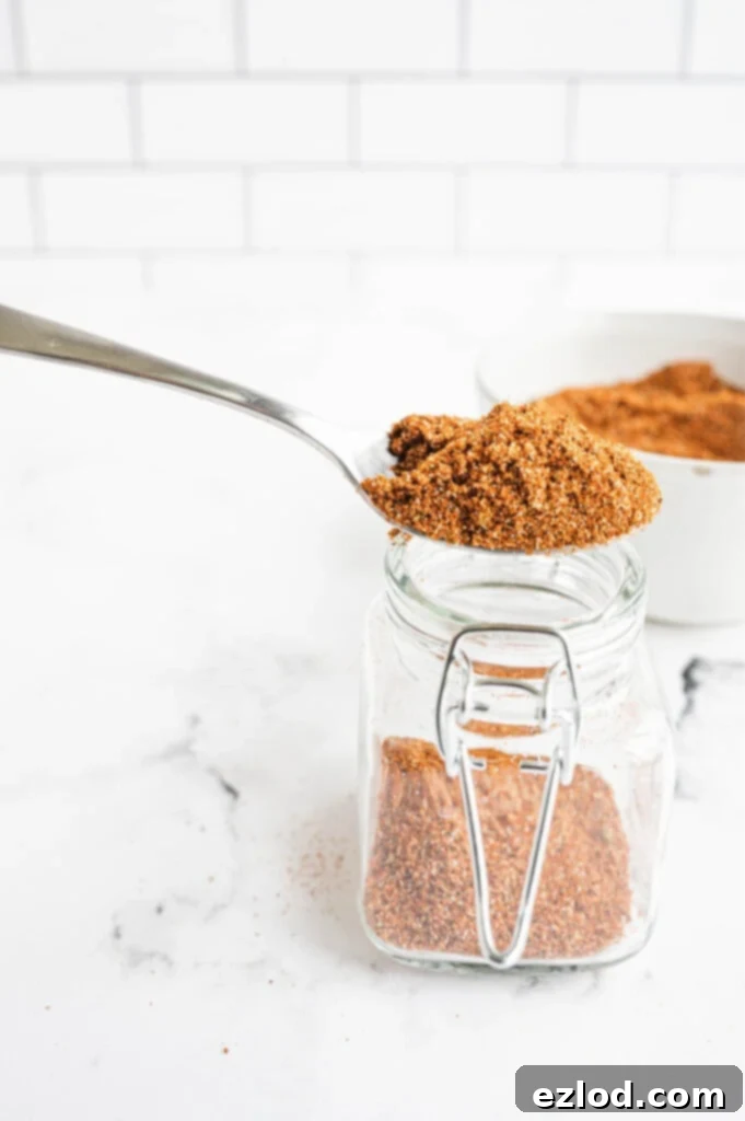 A beautifully composed shot of homemade salt-free taco seasoning displayed in a small, rustic ceramic bowl with a wooden spoon, against a warm, inviting background, highlighting its natural and fresh appeal.