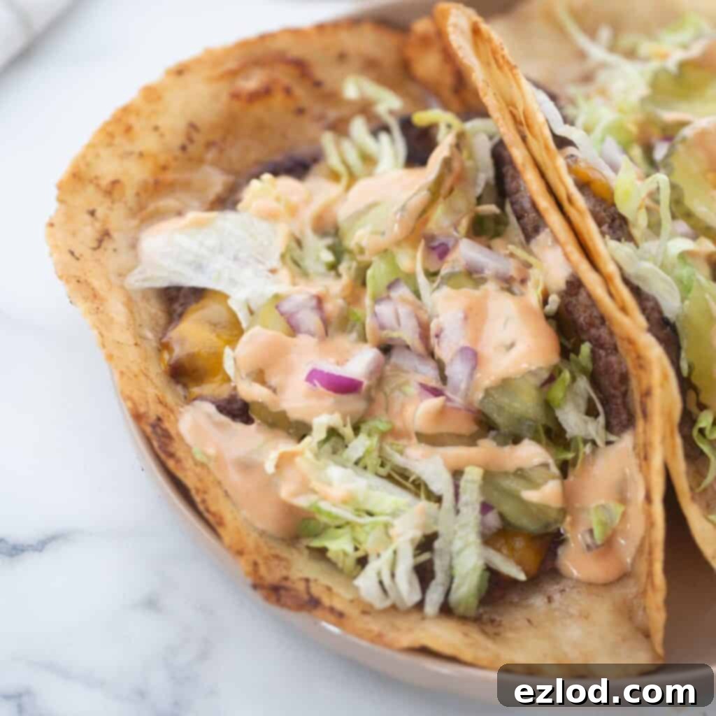 Gluten free big mac tacos topped with lettuce, big mac sauce, pickles and onions.