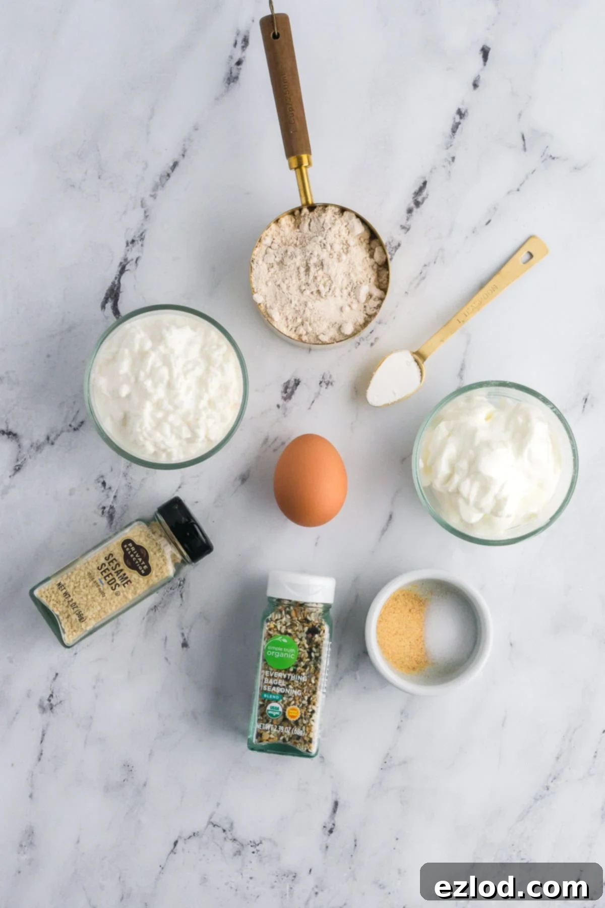 Ingredients for high-protein bagels shot from overhead on a white marble background