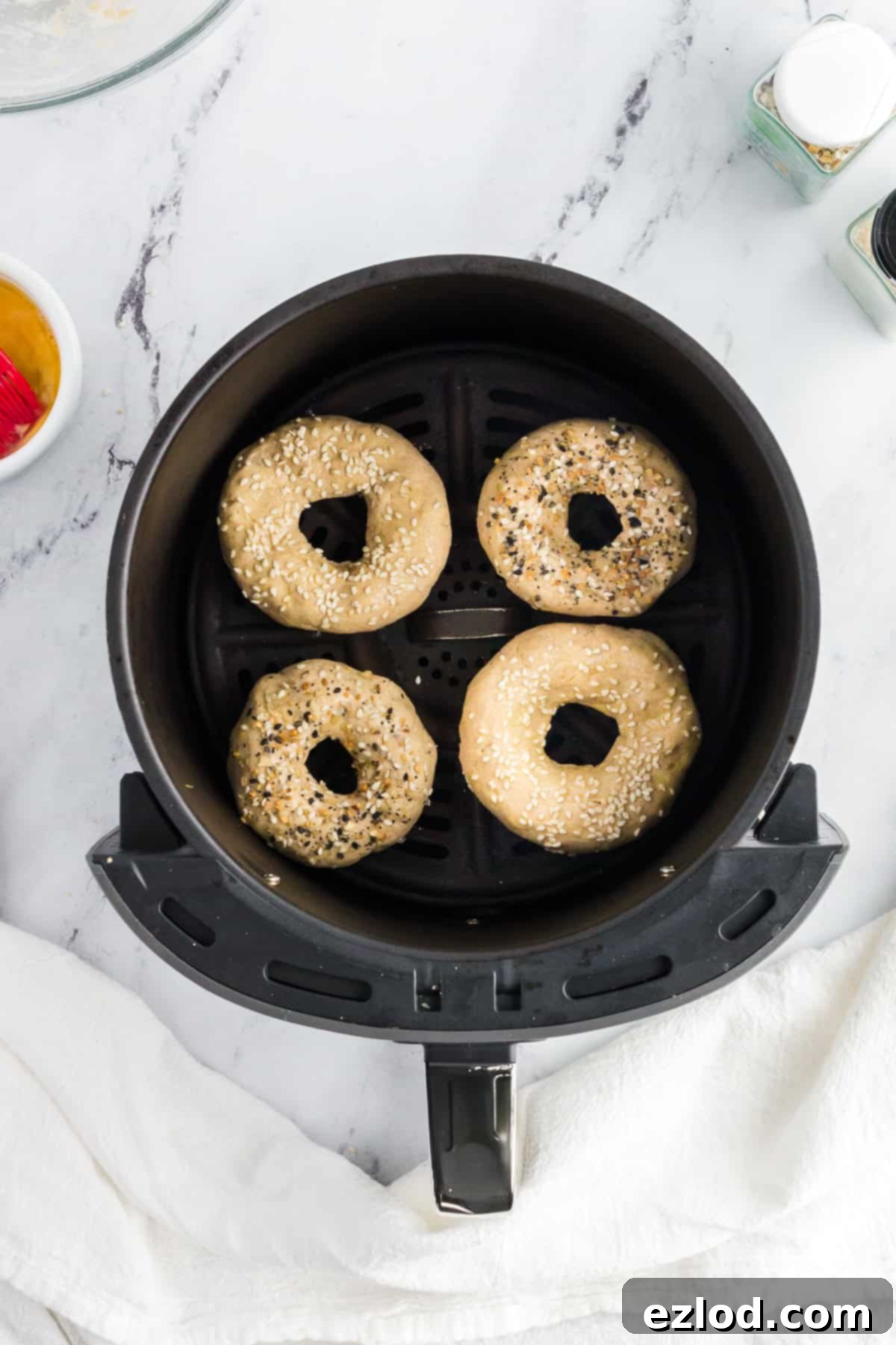 high-protein bagels in an air fryer basket before being cooked