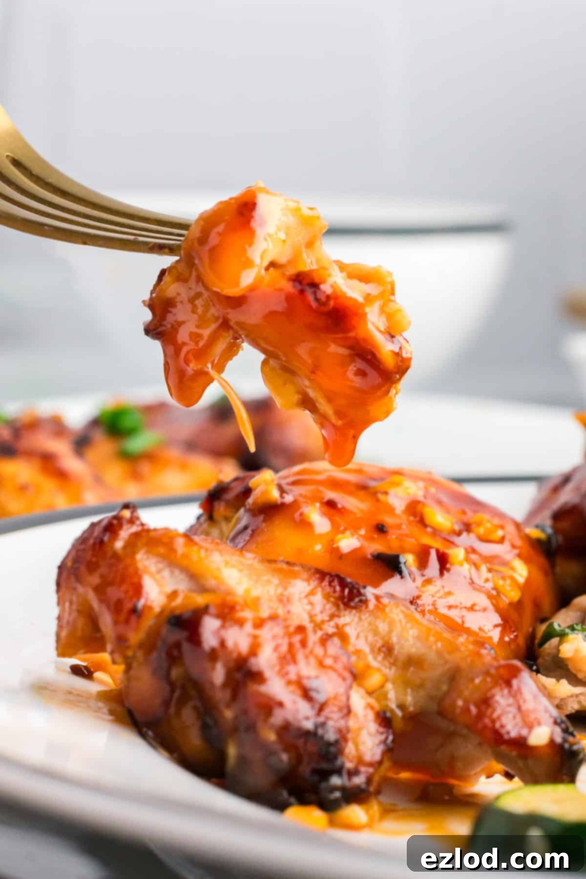 Glazed Sticky Chicken Thighs: Air Fried or Oven Baked 7 a bite of chicken cut off of a chicken thigh coated in sticky glaze