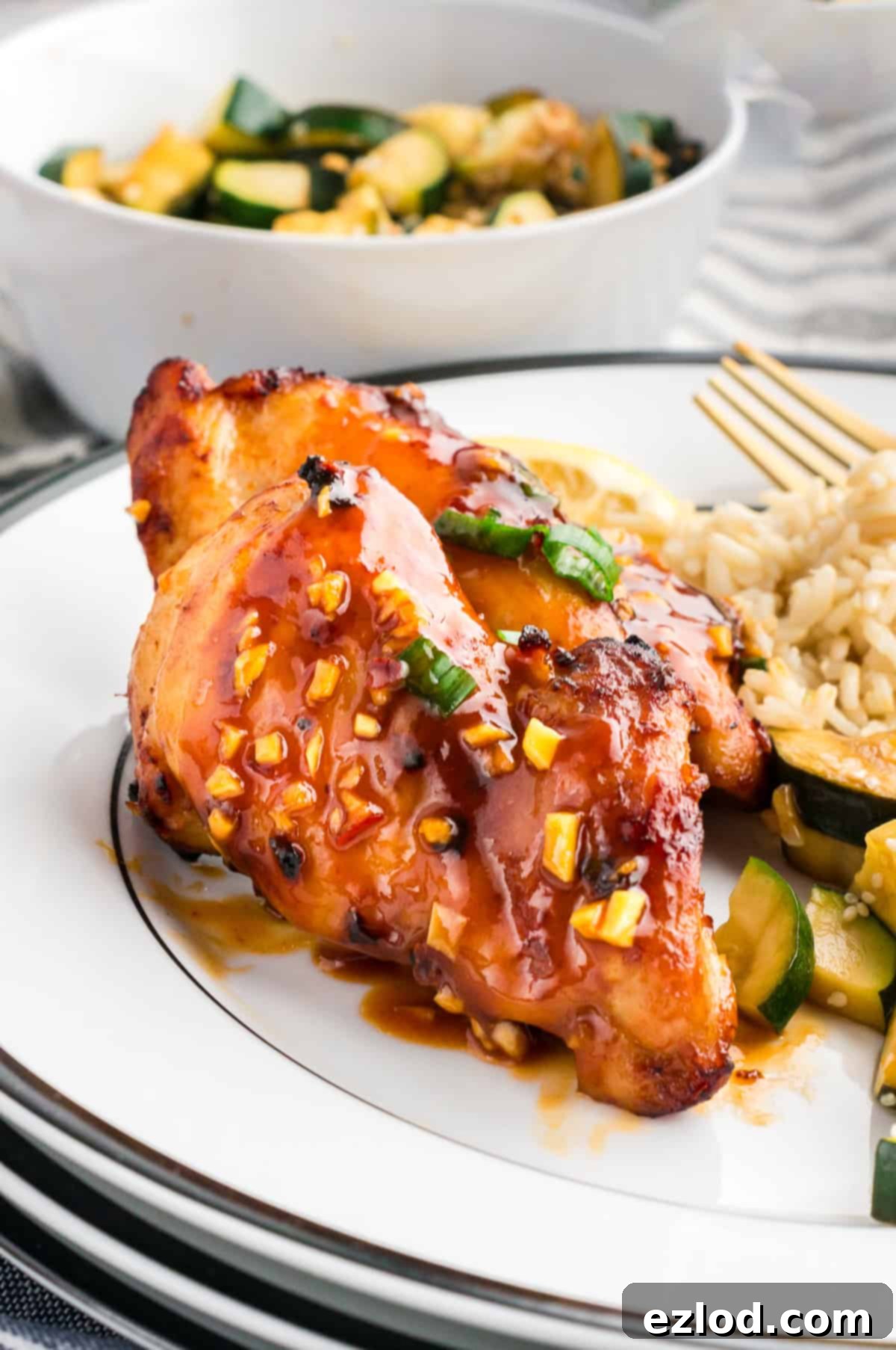 Glazed Sticky Chicken Thighs: Air Fried or Oven Baked 3 A plate with juicy air fryer chicken thigh, rice and veggies.