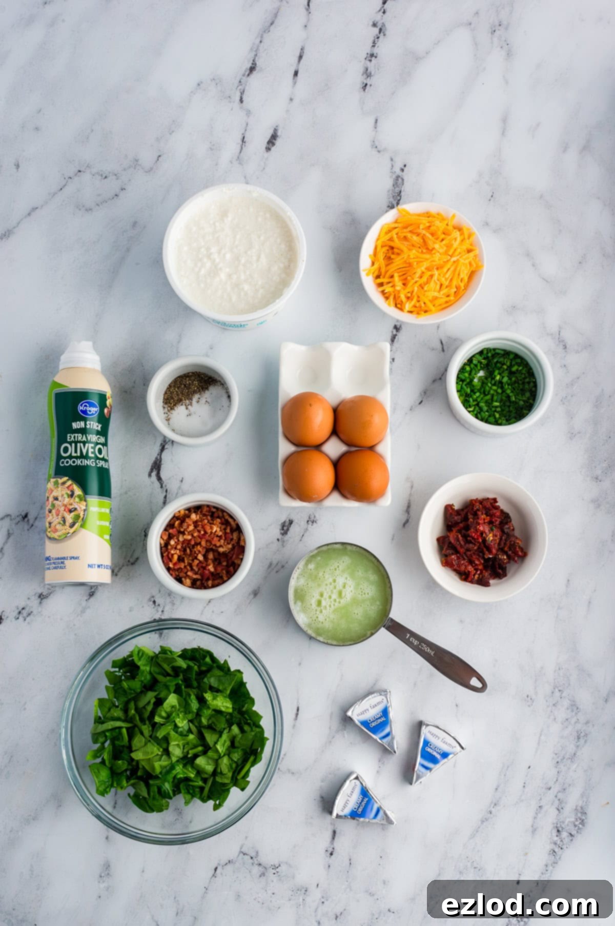 Ingredients for cottage cheese egg bites on a marble background in separate containers.