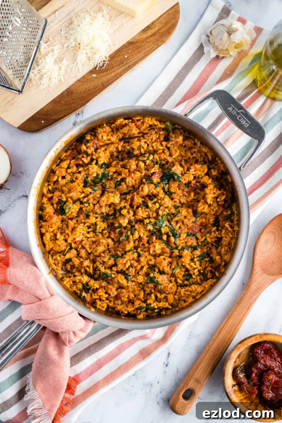 Finished Marry Me Chicken Orzo in a large skillet, resting on a colorful kitchen towel, ready to be served.