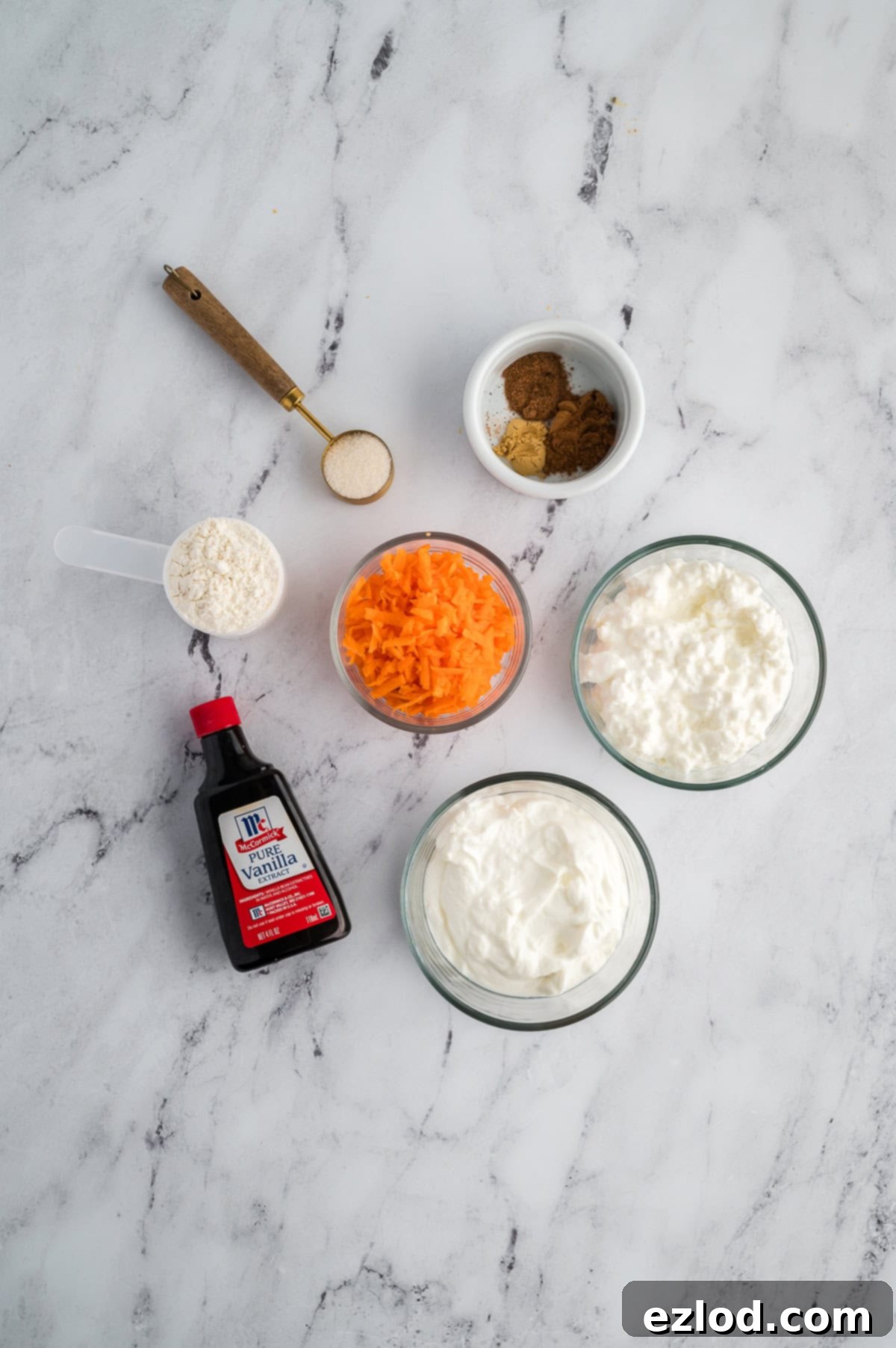 Ingredients for carrot cake cheesecake cups on a marble background in separate containers.