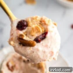 High-Protein No-Bake Carrot Cake Cheesecake Cups with crumbled graham crackers and raisins on top, ready to be enjoyed.
