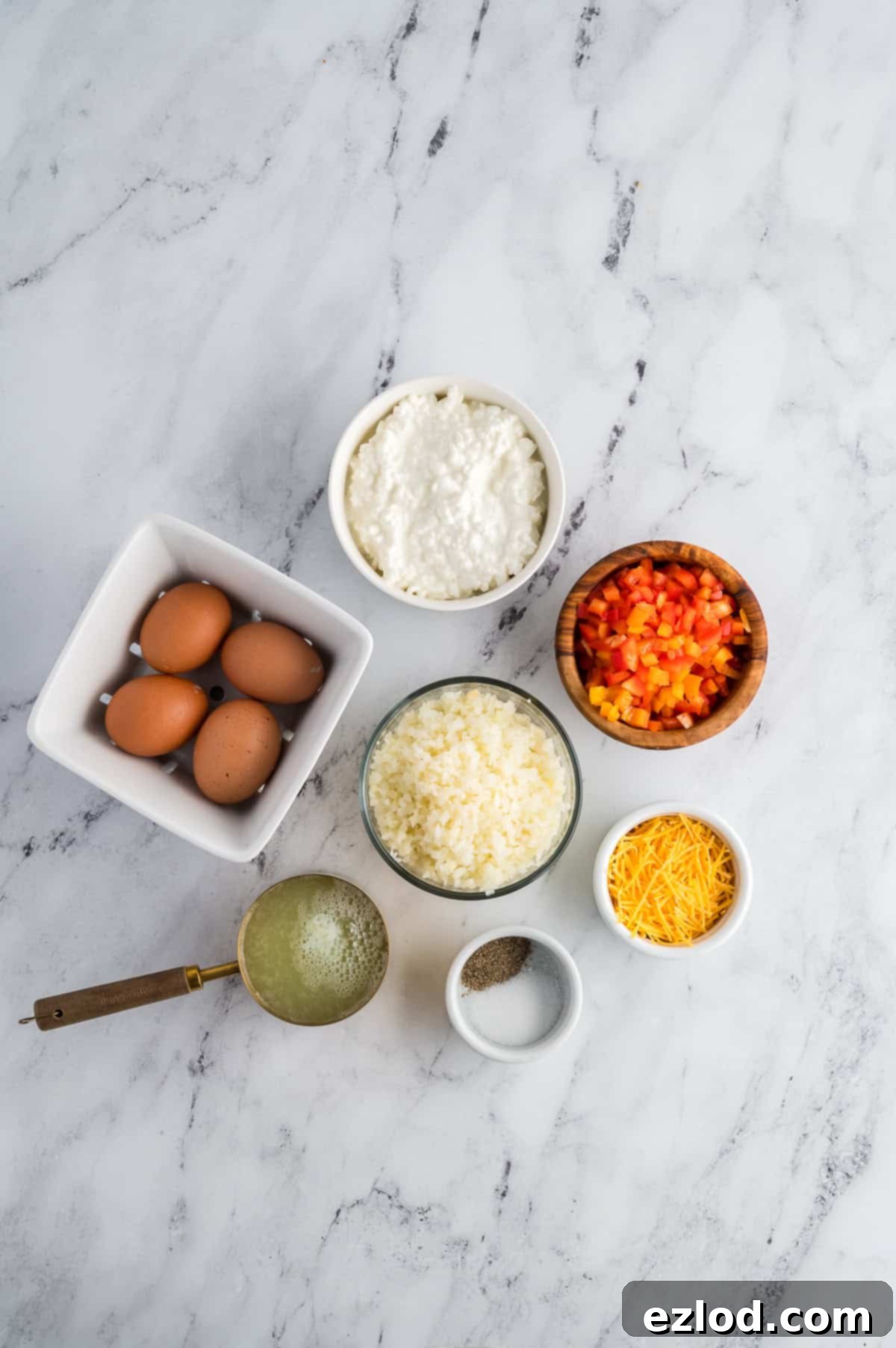 Ingredients for breakfast bowls in separate containers on a marble background.