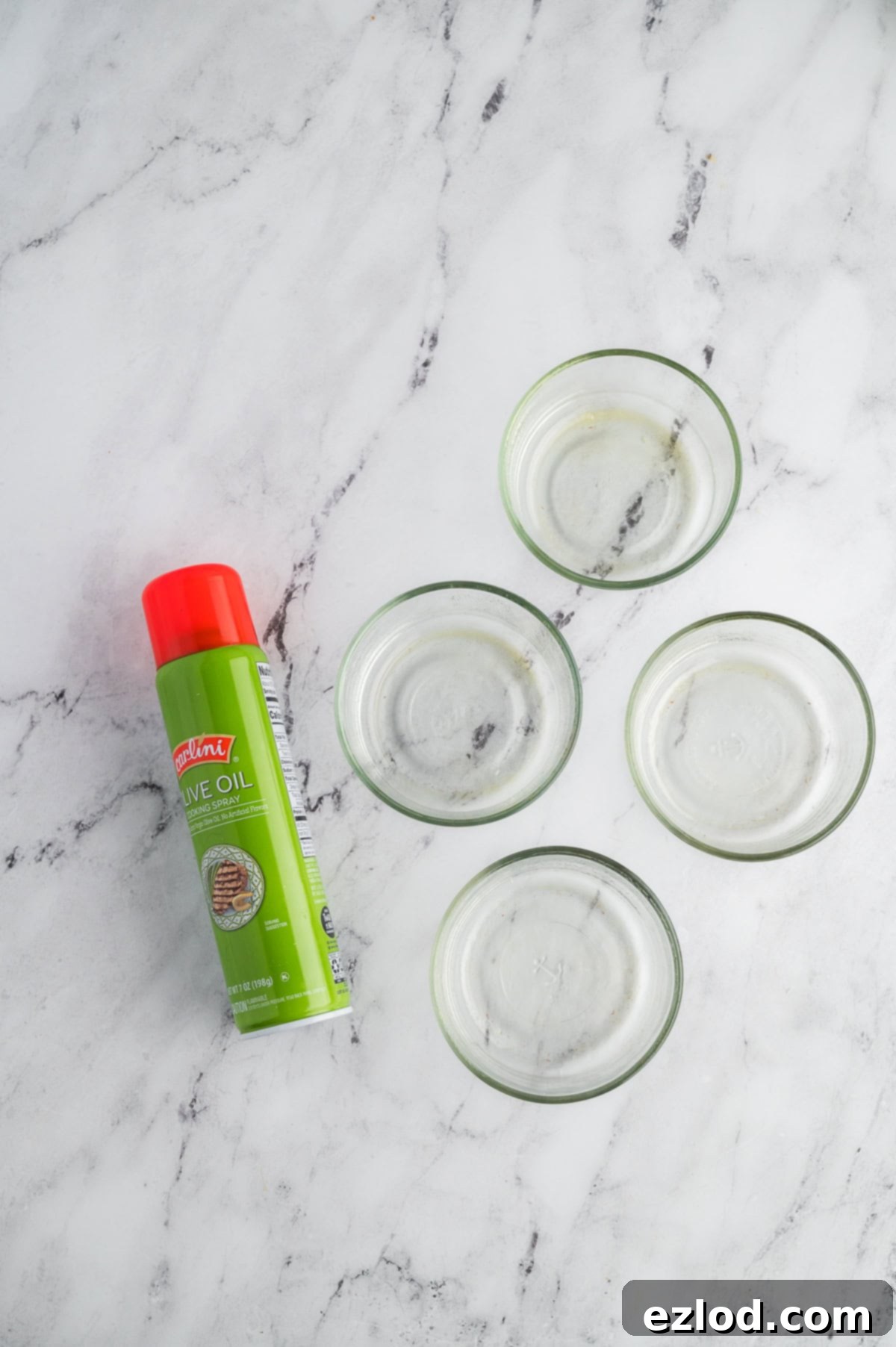 Individual dishes for breakfast bowls on a marble counter pictured with cooking spray.